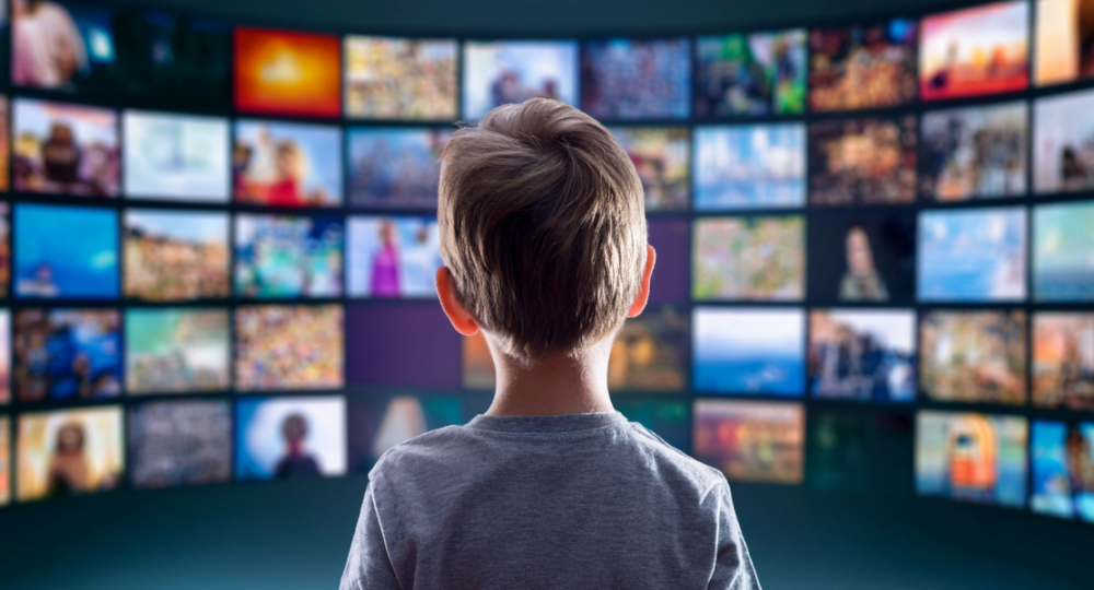 Pojke framför skärmar med film